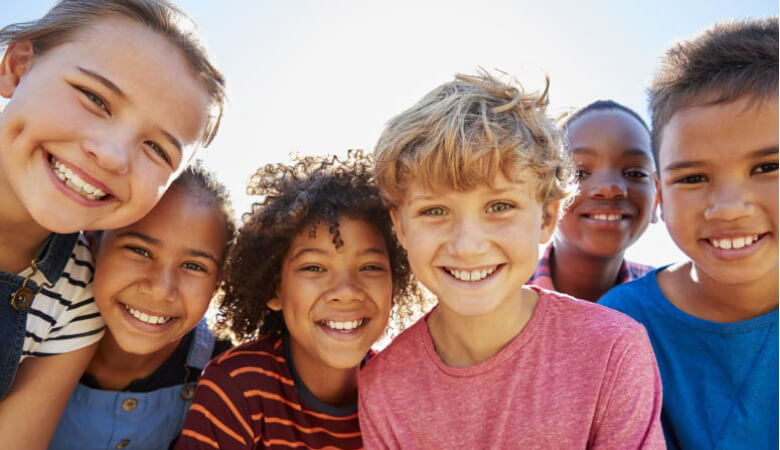 group of kids back to school and smilng showing off their pearly whites