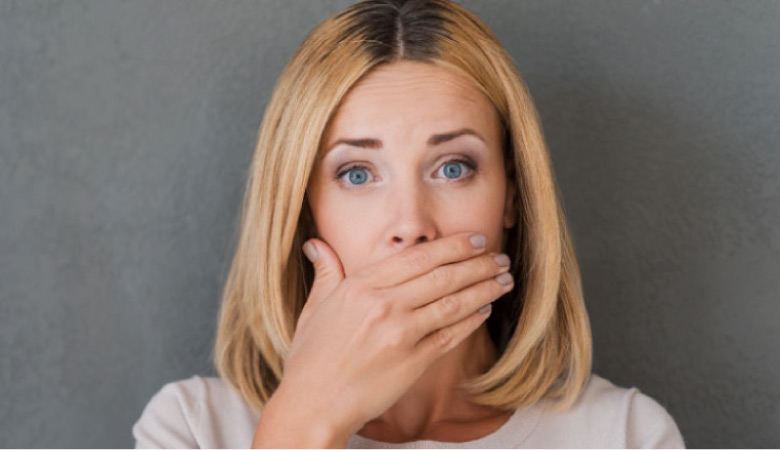woman covering her mouth with her hand to hide gum disease