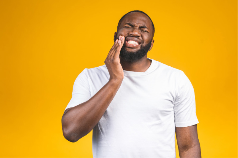 man holding his jaw in pain from bone loss