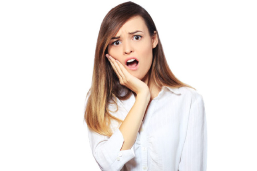 young woman holding her jaw in pain with a dental emergency