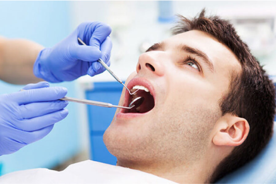 young man in the dentist chair getting an oral cancer screening