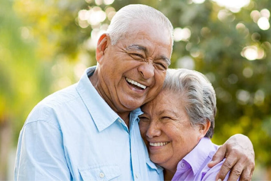 senior couple hug and smile after learning how to care for their dentures