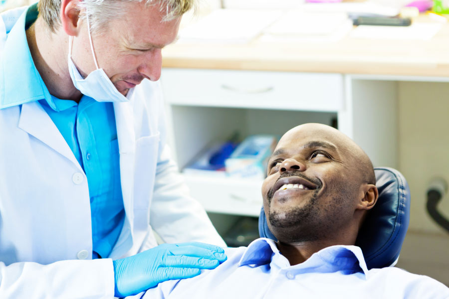 male dental patient gets ready for a deep cleaning by the dentist